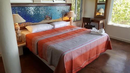 a bedroom with a large bed with a red blanket at Casa Ofelia in Mazunte