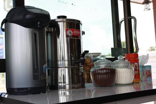 a coffee maker sitting on a counter next to some food at Metha Palace in Sakon Nakhon