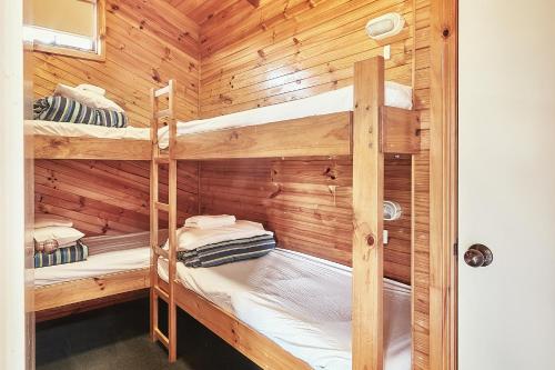 a wooden cabin with two bunk beds in it at Anglesea Family Caravan Park in Anglesea