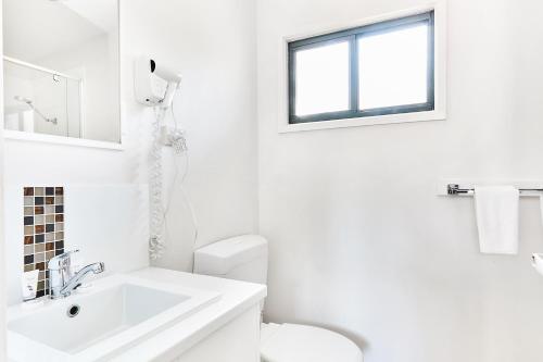 a white bathroom with a sink and a toilet at Anglesea Family Caravan Park in Anglesea