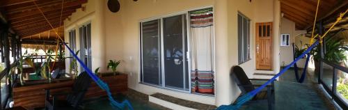 a porch with two chairs in front of a house at Casa Ofelia in Mazunte