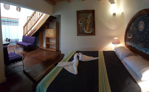 a bedroom with a large bed and a living room at Casa Ofelia in Mazunte