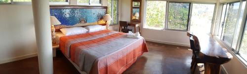 a bedroom with a bed in a room with windows at Casa Ofelia in Mazunte