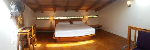 a bedroom with a bed and a desk and a window at Casa Ofelia in Mazunte