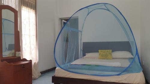 a bed with a canopy in a room at Priyanna Guest, Forest view in Polonnaruwa