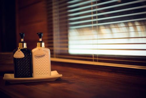 two bottles ofodorizers sitting on a table next to a window at Panvaree The Greenery in Ban Chieo Ko
