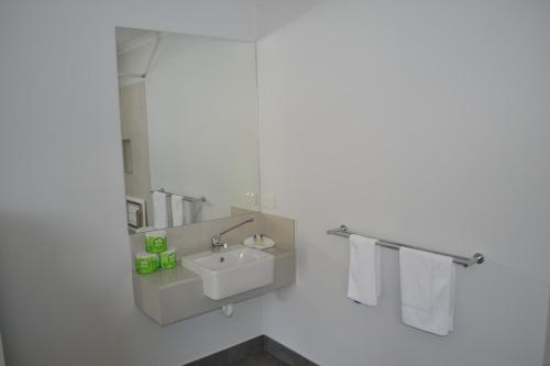 a white bathroom with a sink and a mirror at Yarrawonga Holiday Park in Yarrawonga