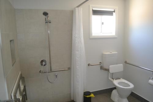 a bathroom with a shower with a toilet and a window at Yarrawonga Holiday Park in Yarrawonga
