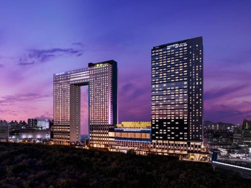 due edifici alti in una città di notte di ibis Styles Ambassador Seoul Yongsan a Seul