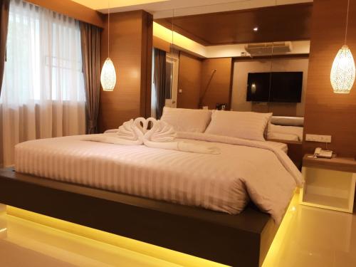 a bedroom with a large white bed in a room at Nava Grand in Ban Talat Rangsit