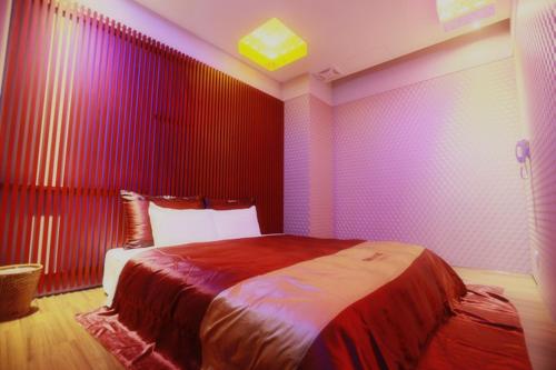 a bedroom with a large bed with red and purple walls at Yosemite Motel - Chunghua Branch in Taichung