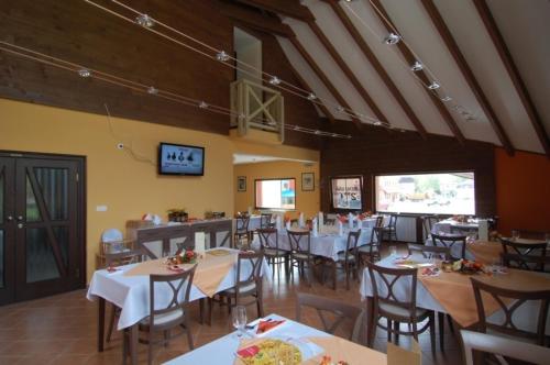 Penzion Solisko في زازريفا: غرفة طعام مع طاولات وكراسي بيضاء
