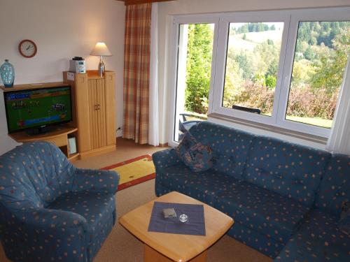 a living room with a couch and a chair and a table at Haus Reimann in Altenau