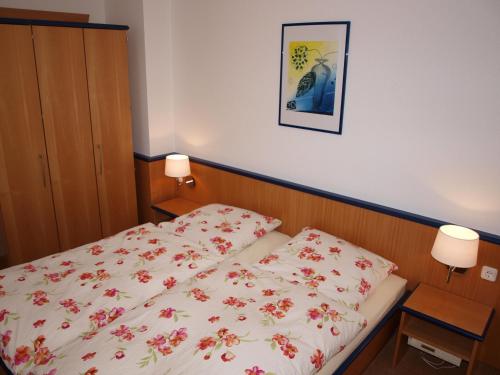 a bedroom with a bed with a floral bedspread at Haus Reimann in Altenau