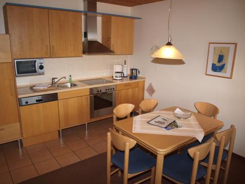 a kitchen with a table and chairs and a kitchen with a sink at Haus Reimann in Altenau