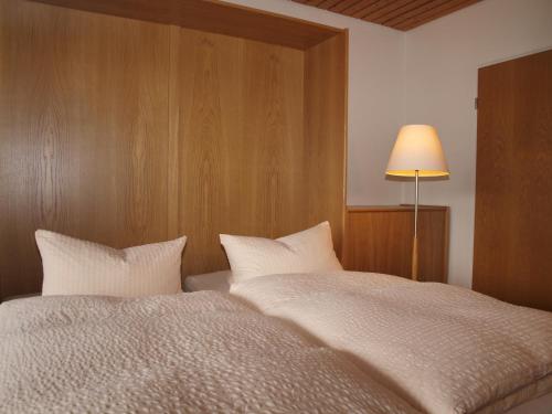 a bedroom with a large bed and a lamp at Haus Reimann in Altenau