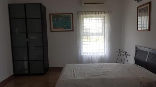 a bedroom with a large bed and a window at Elysium Kovalam in Chennai