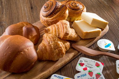 a tray of bread and pastries on a table at HOTEL MYSTAYS Nagoya Sakae in Nagoya