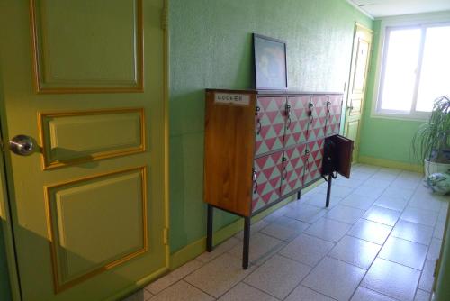 a room with a door and a cabinet and a window at The House Hostel in Sokcho