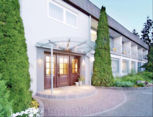 a large white building with a wooden door at Hotel zur Sonne GmbH in Bodelshausen
