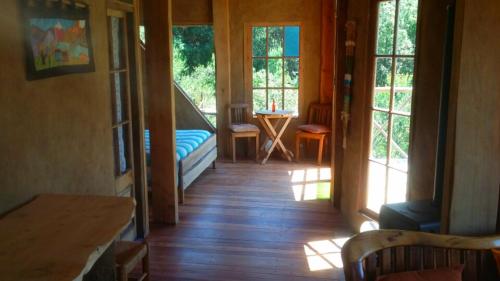 a hallway of a house with a bed and windows at Cabaña Cajón del Maipo in San José de Maipo