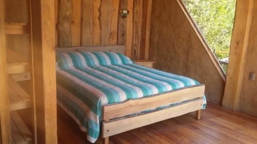 a bed in a cabin with a wooden floor at Cabaña Cajón del Maipo in San José de Maipo