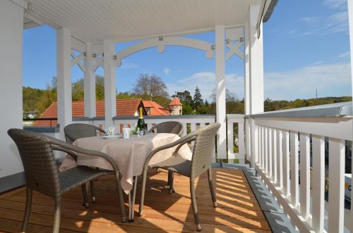奥斯赛拜-塞林Villa Annika - Apt. 11的白色的门廊上摆放着桌椅