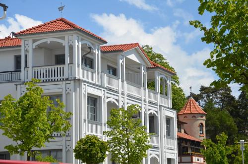 un grand bâtiment blanc avec un toit rouge dans l'établissement Villa Annika - Apt. 02, à Sellin