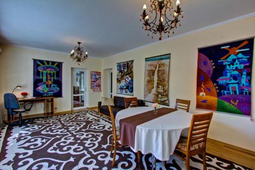 a dining room with a table and a chandelier at Green Yard Hotel in Karakol