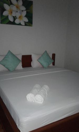 a bed with two rolled up towels on it at Chika House in Gili Trawangan