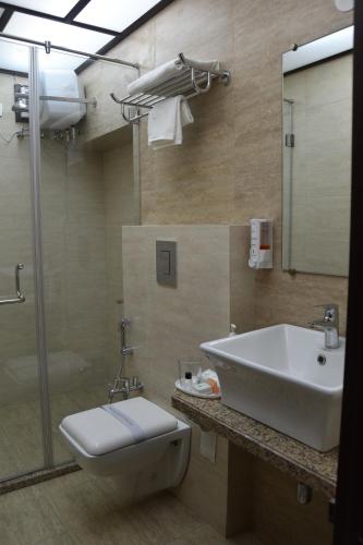 a bathroom with a sink and a toilet and a shower at Jaipur Hotel New - Heritage Hotel in Jaipur
