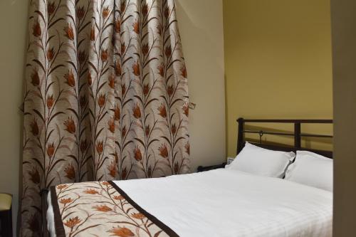 a bedroom with a bed with a large headboard at Jaipur Hotel New - Heritage Hotel in Jaipur
