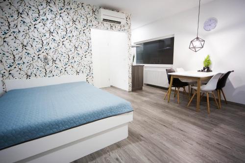 Schlafzimmer mit einem Bett und einem Tisch mit Stühlen in der Unterkunft Luxury Studio Apartments in Ljubljana