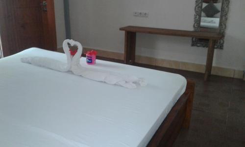 two swans made out of towels sitting on a bed at Chika House in Gili Trawangan