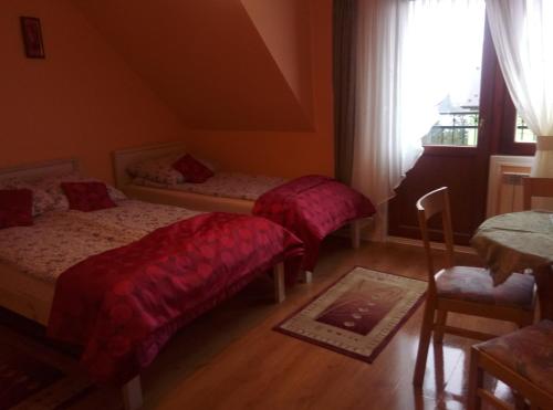 sypialnia z dwoma łóżkami i oknem w obiekcie Willa na Skarpie w Kluszkowcach