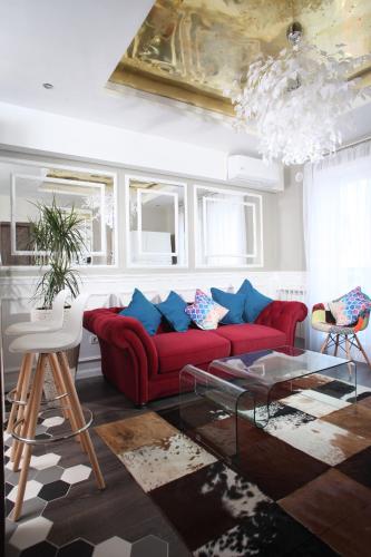 a living room with a red couch and blue pillows at Casa Mia - Modern Luxury Apartament in Bucharest