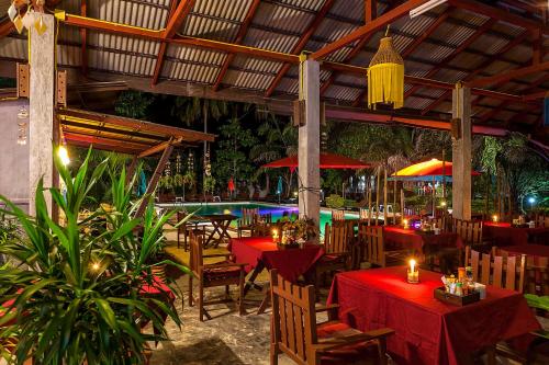 restauracja ze stołami i krzesłami oraz basenem w obiekcie Lanta Klong Nin Beach Resort w mieście Ko Lanta
