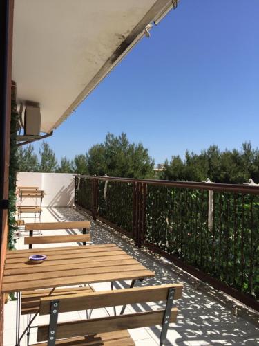 una fila de bancos de madera en un patio en B&B Le Saline en Taranto