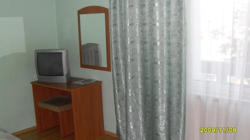 a room with a television and a mirror and a curtain at Germanea Hotel in Sapareva Banya