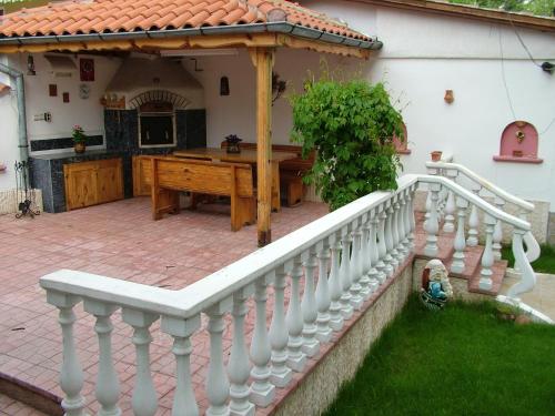 a patio with a wooden table and a white fence at Family Hotel Emaly 1 in Bankya