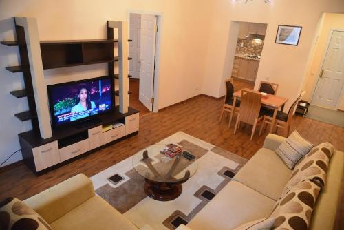 a living room with a couch and a flat screen tv at City Mansion ApartHotel in Baku