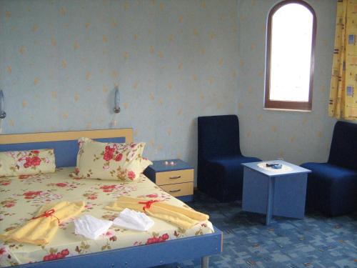 a bedroom with a bed and two blue chairs at Family Hotel Emaly 1 in Bankya