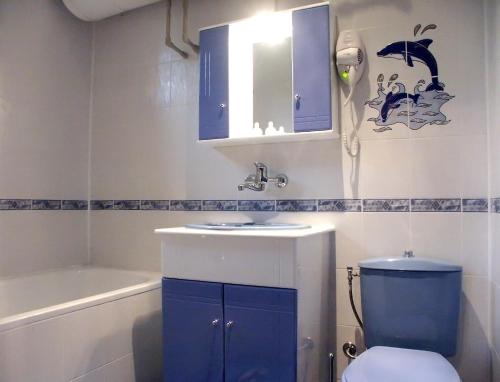 La salle de bains est pourvue d'un lavabo bleu et de toilettes. dans l'établissement Family Hotel Emaly 1, à Bankya