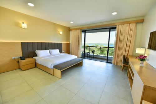 a hotel room with a bed and a balcony at K Hotels Entebbe in Entebbe