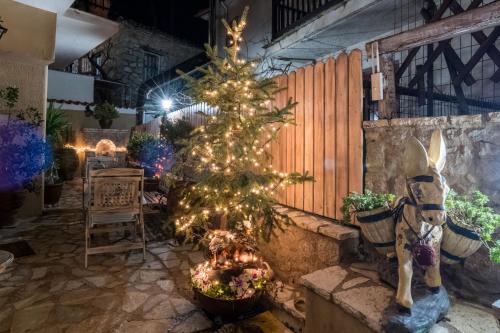 a christmas tree and a horse in a room at Lykovrisi Guest House in Arachova