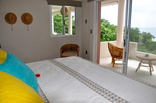 a bedroom with a large bed and a balcony at Casa Cometa in San Agustinillo