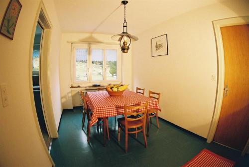 ein Esszimmer mit einem Tisch und einer Obstschale darauf in der Unterkunft Casa Agriturismo Mattei in Peccia