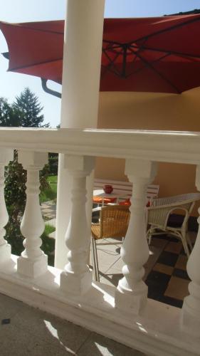 a white porch with a table and chairs at Gästehaus Tante Tienchen 7 Minuten zu Fuss zum Europa Park , plus kostenloses Parkplatzticket Rulantica ,alle unsere Suiten haben einen Balkon in Rust