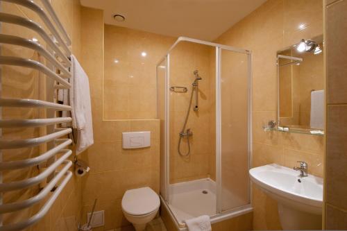 een badkamer met een douche, een toilet en een wastafel bij Hotel Hetmański in Rawa Mazowiecka