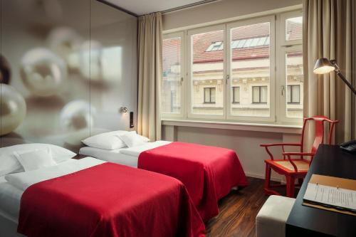 a hotel room with two beds and a window at Perla Hotel in Prague